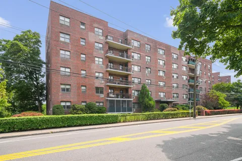 a view of a tall building next to a yard