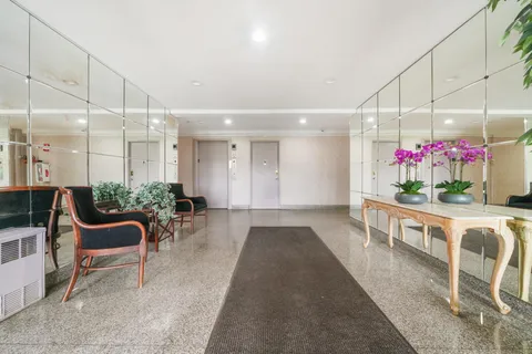 a view of a dining room filled with furniture and a chandelier