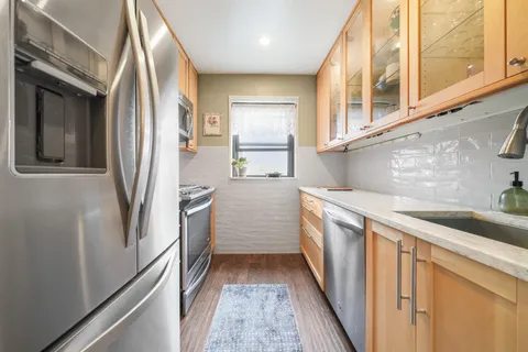 a kitchen with stainless steel appliances granite countertop a refrigerator and a sink