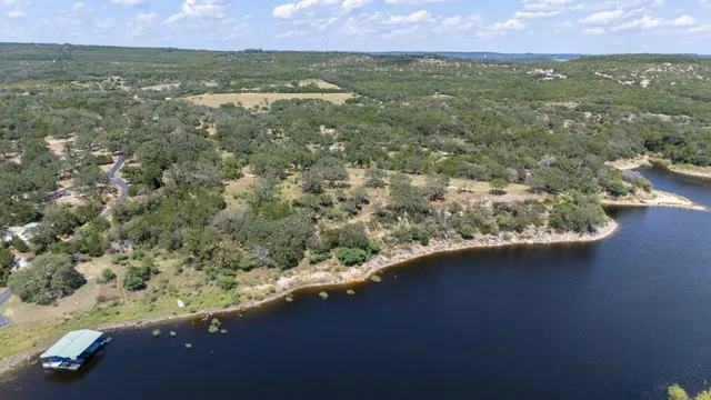 an aerial view of residential houses with outdoor space and trees