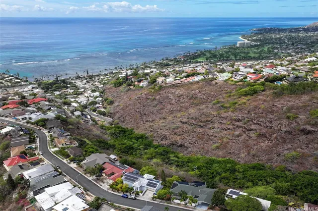 an aerial view of house with yard and mountain view in back