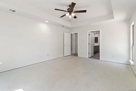 an empty room with ceiling fan and window