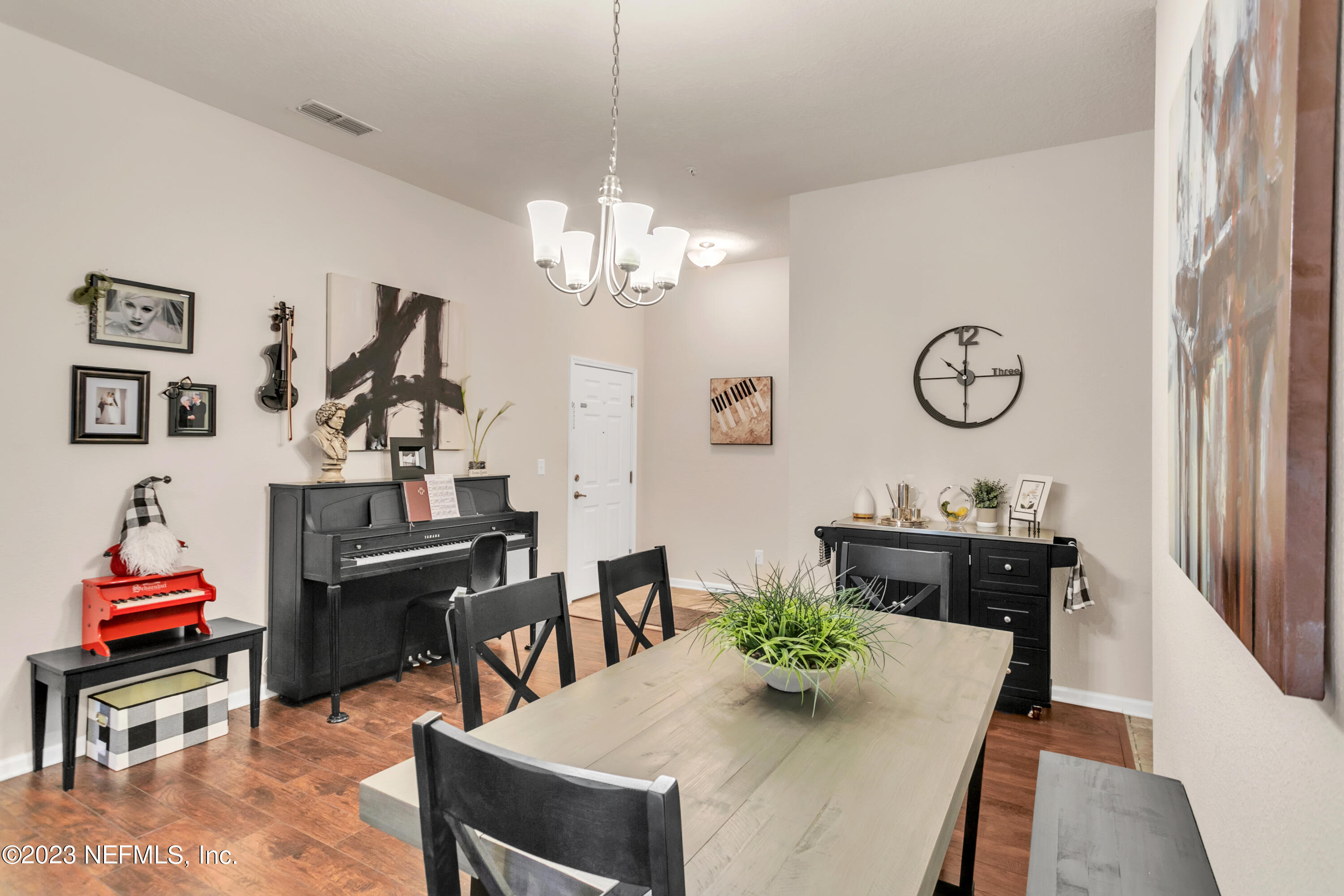 200 Larkin Place, Unit 101 St. Johns, FL 32259 - Photo 2 of 29 a view of a dining room with furniture a chandelier and wooden floor