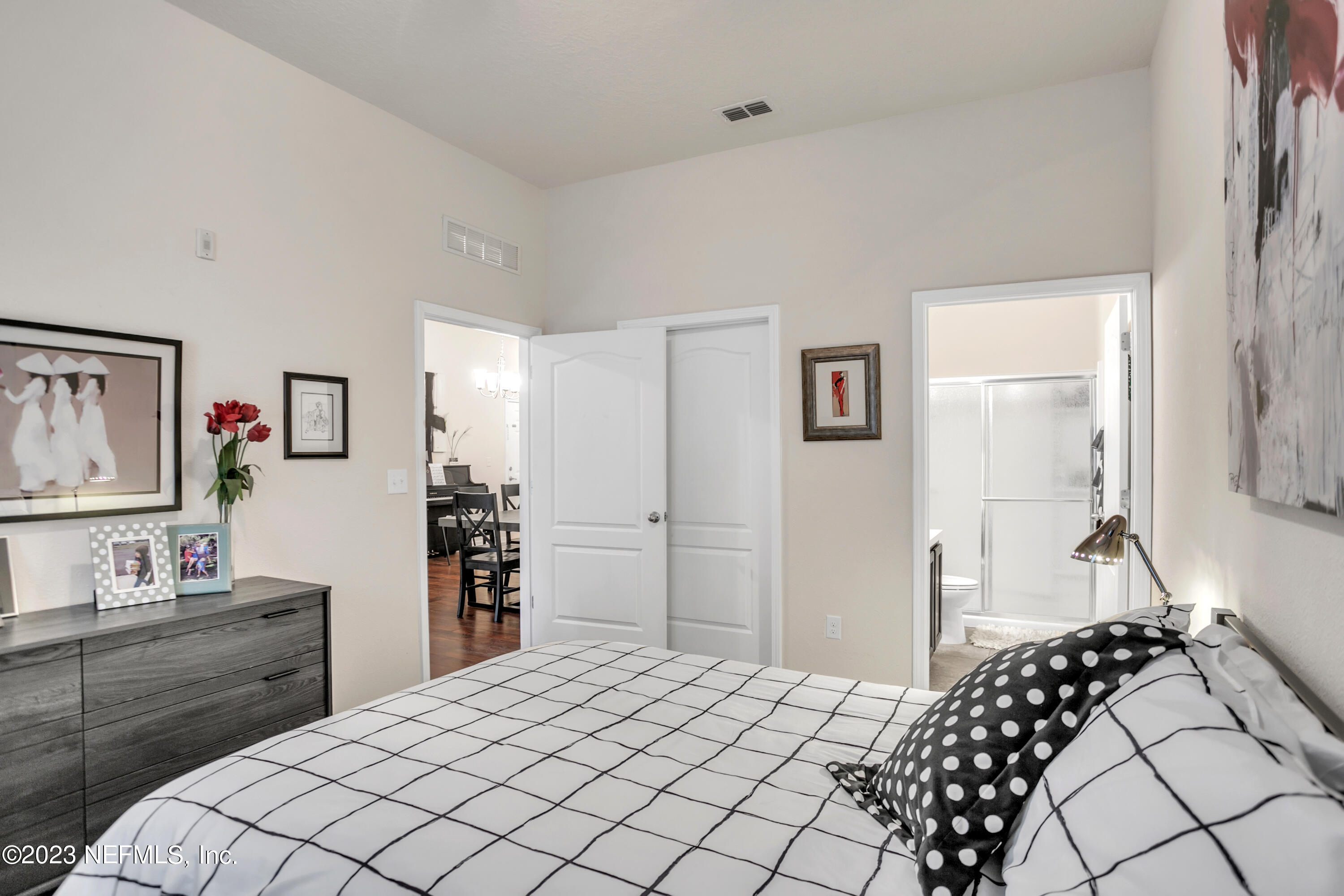 200 Larkin Place, Unit 101 St. Johns, FL 32259 - Photo 7 of 29 a bedroom with a bed and dresser with mirror
