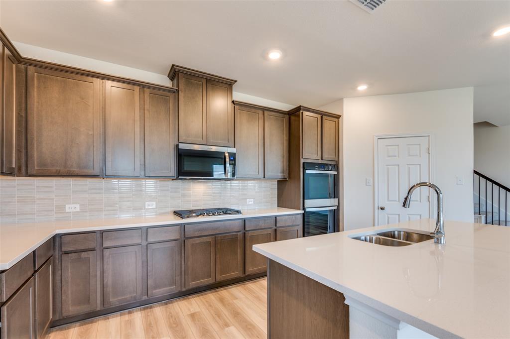 341 Fallbrook Drive Aledo, TX 76008 - Photo 9 of 40 Kitchen with light wood finished floors, light countertops, stainless steel appliances, recessed lighting, and tasteful backsplash