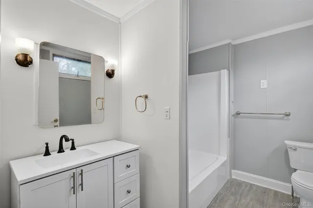 a bathroom with a sink a toilet a mirror and shower