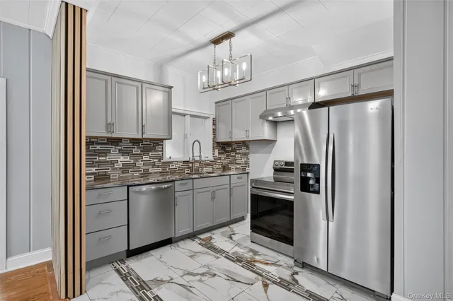 a kitchen with stainless steel appliances granite countertop a refrigerator and a stove top oven