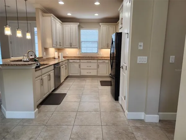 a kitchen with stainless steel appliances granite countertop a refrigerator and a sink