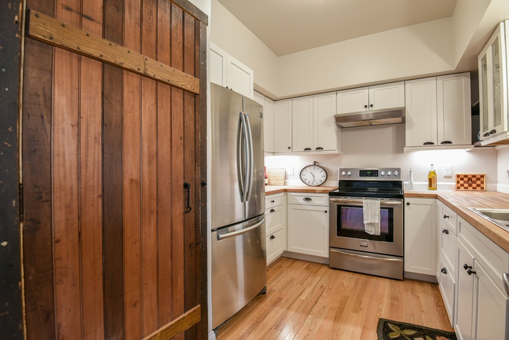 32 North Prospect Street, Unit 4 Amherst, MA 01002 - Photo 5 of 29 a kitchen with a stove cabinets and a refrigerator