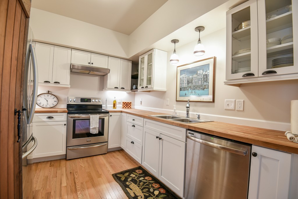 32 North Prospect Street, Unit 4 Amherst, MA 01002 - Photo 6 of 29 a kitchen with stainless steel appliances a sink cabinets and wooden floor