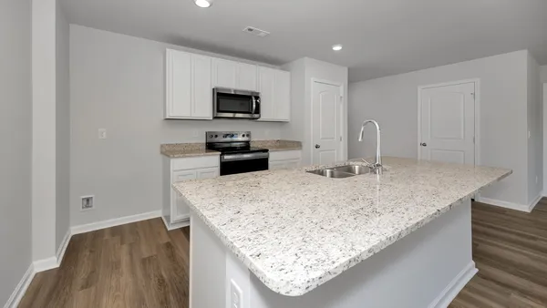 a kitchen with stainless steel appliances granite countertop a sink and a stove with wooden floor