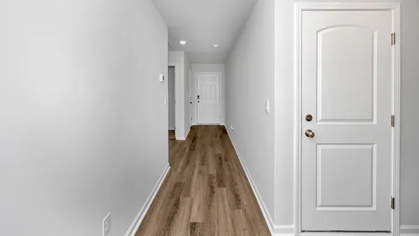 a view of a hallway with wooden floor and staircase
