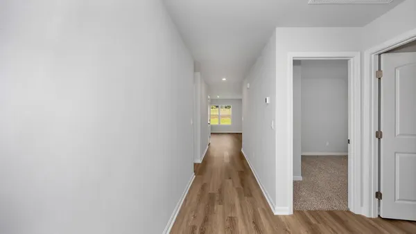 a view of a hallway with wooden floor and staircase