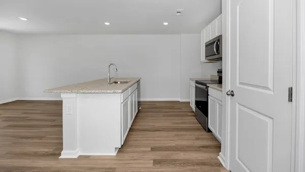 a view of a kitchen with a sink and wooden floor