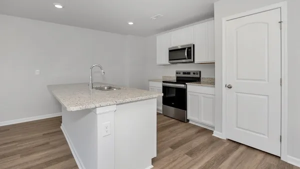 a view of kitchen with granite countertop stainless steel appliances sink stove microwave and refrigerator