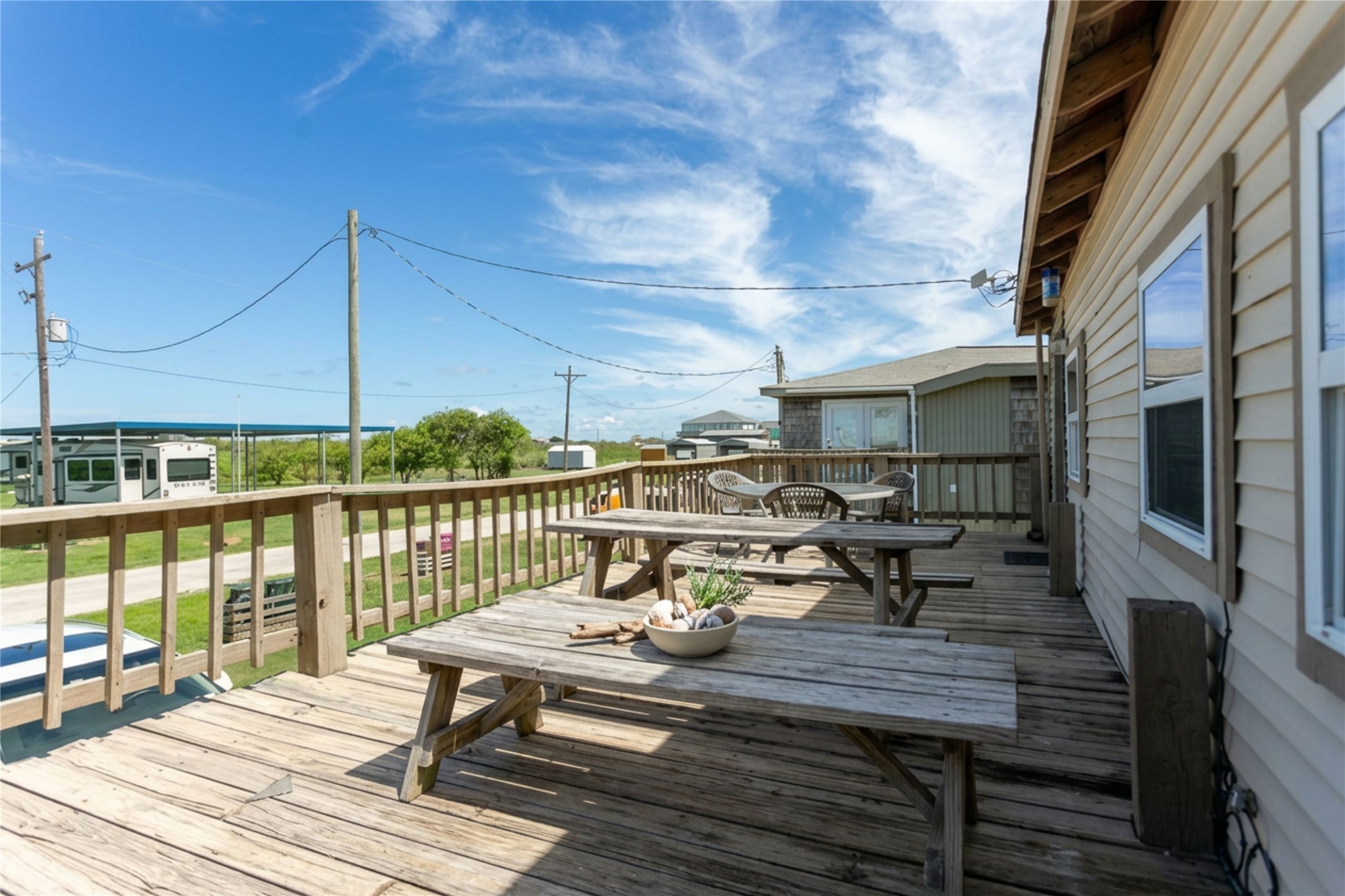 959 South East Road Crystal Beach, TX 77650 - Photo 4 of 20 a view of a balcony with chairs and wooden floor