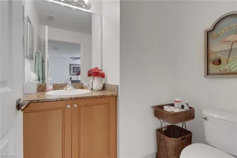a bathroom with a granite countertop toilet sink and mirror