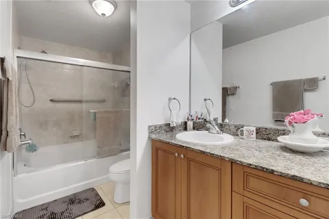 a bathroom with a granite countertop sink mirror toilet and bathtub