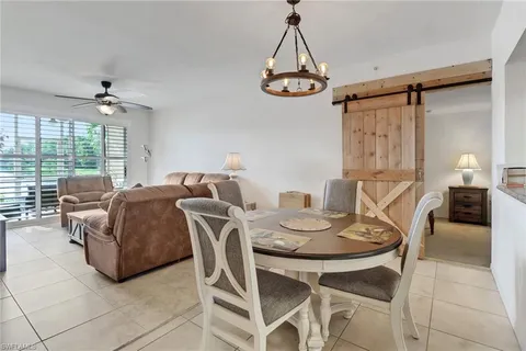 a living room with furniture a chandelier and a window
