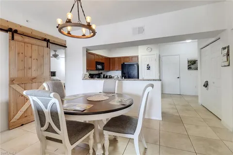 a dining room with furniture a chandelier and kitchen view