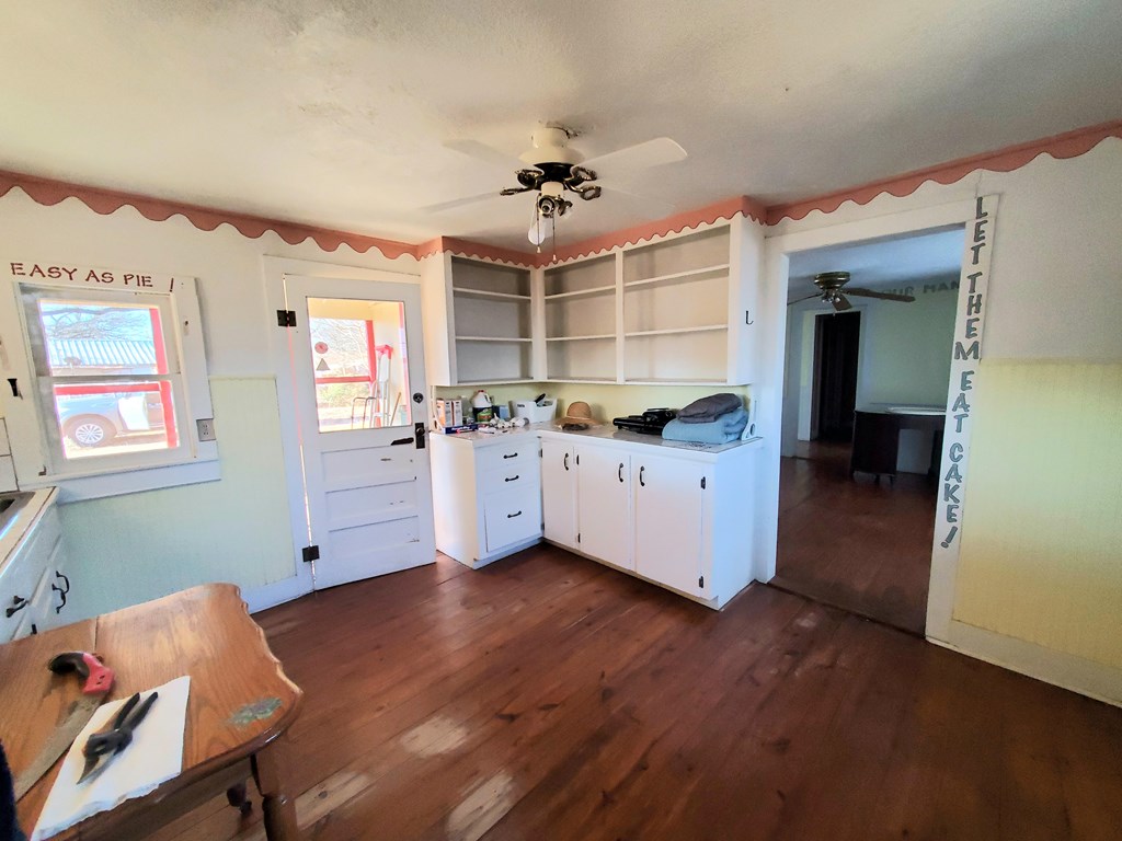 631 Millard Street Mason, TX 76856 - Photo 5 of 16 a kitchen with stainless steel appliances kitchen island hardwood floor sink stove and window