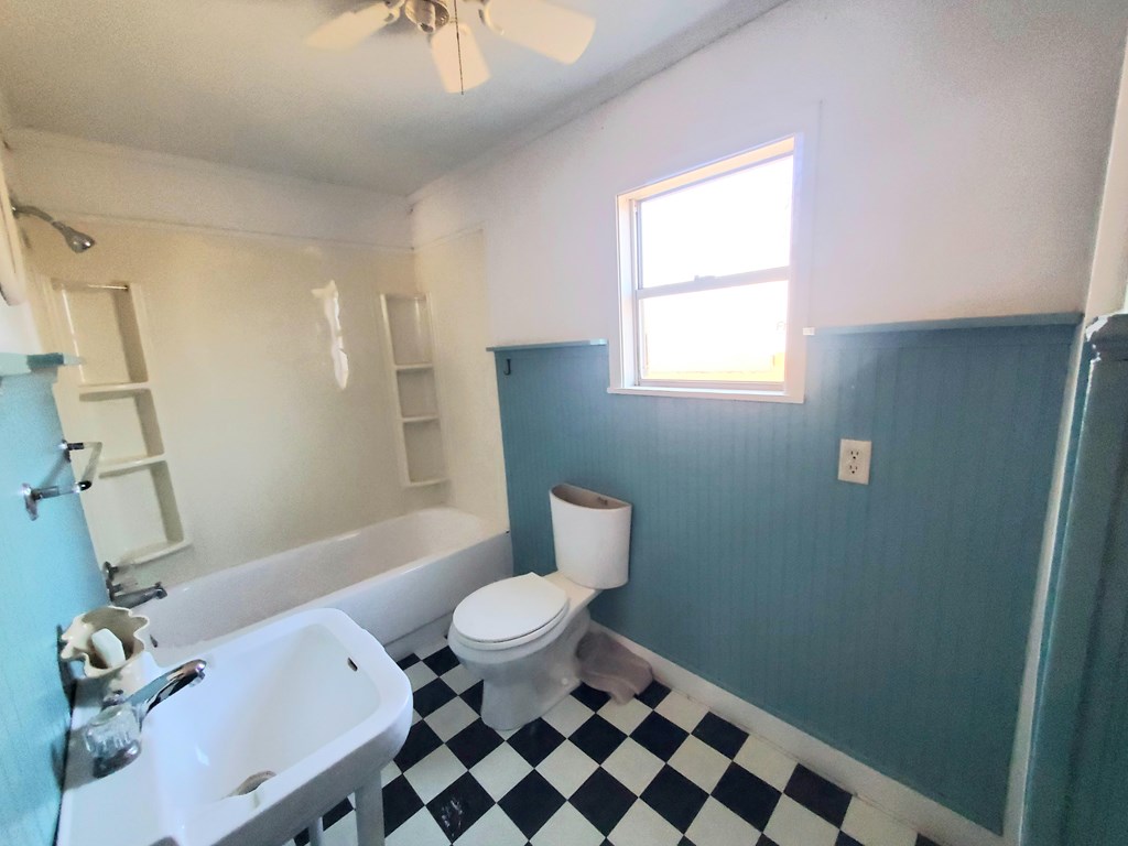631 Millard Street Mason, TX 76856 - Photo 7 of 16 a bathroom with a granite countertop sink toilet a mirror and shower