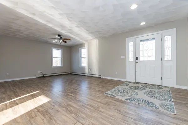 a kitchen with stainless steel appliances granite countertop a refrigerator a sink dishwasher a stove and a wooden floor