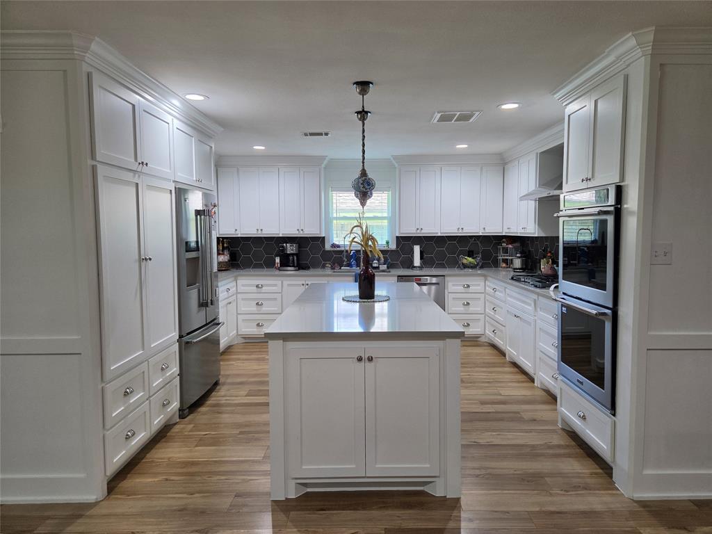 1023 Ridgefield Drive Plano, TX 75075 - Photo 10 of 39 a kitchen with counter top space cabinets and stainless steel appliances