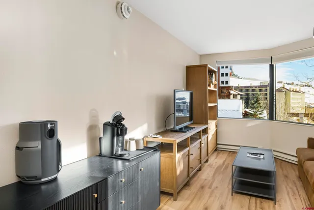 a view of a workspace with furniture and a window