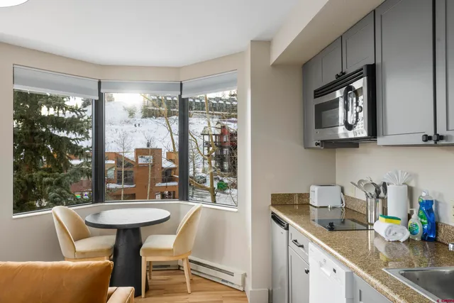 a kitchen with a table chairs sink and cabinets