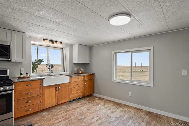 a kitchen with stainless steel appliances granite countertop a stove a sink and a refrigerator