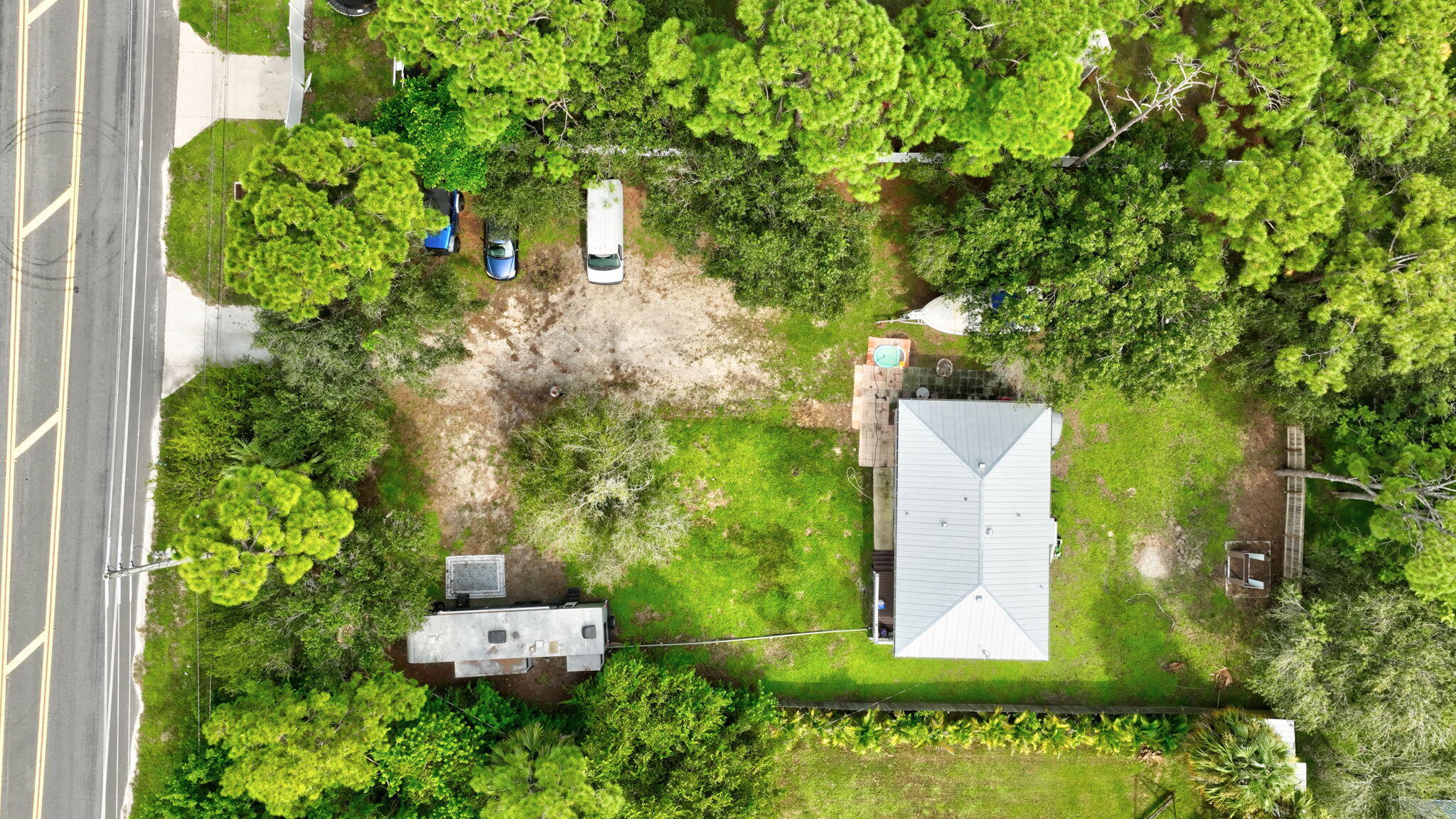 9555 Orange Avenue Fort Pierce, FL 34945 - Photo 1 of 28 an aerial view of a house with a yard and large trees