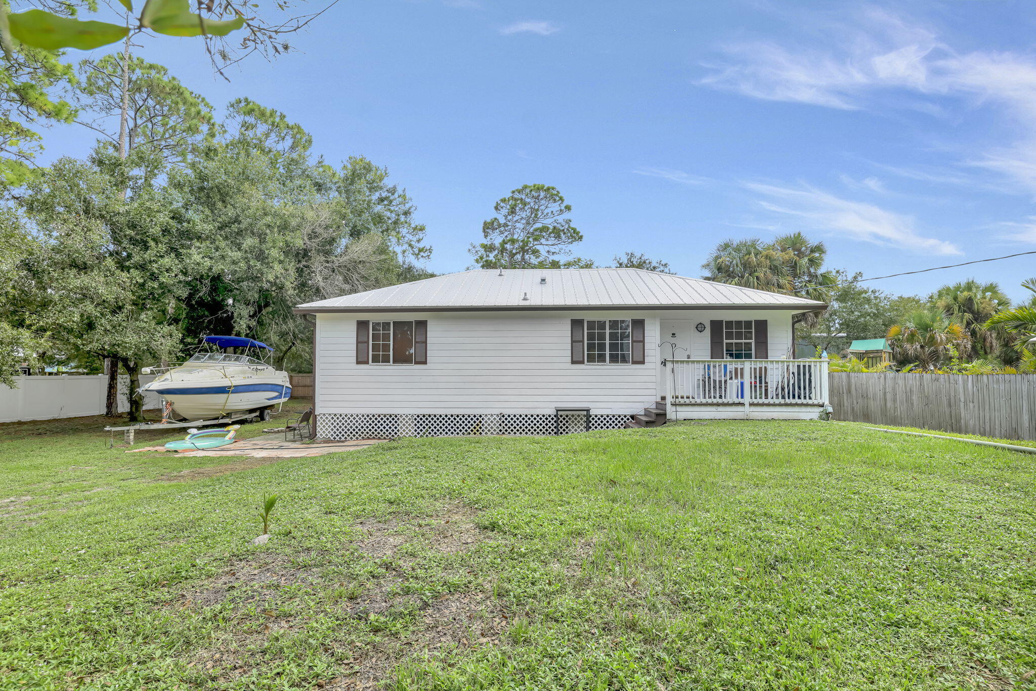 9555 Orange Avenue Fort Pierce, FL 34945 - Photo 12 of 28 a front view of a house with a garden and deck