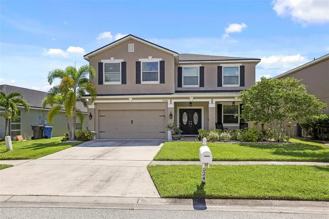 a front view of a house with a yard and garage