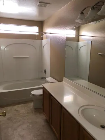 a living room with a window and a ceiling fan