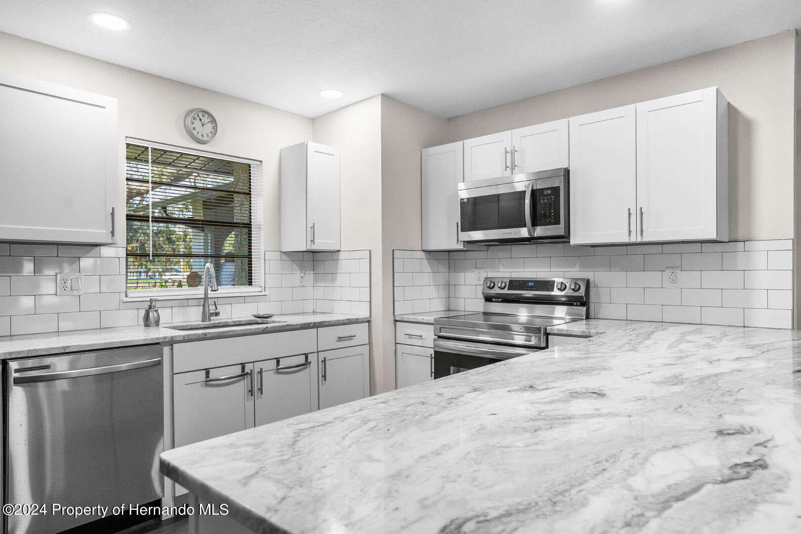 2004 Nobleton Avenue Spring Hill, FL 34608 - Photo 14 of 38 a kitchen with stainless steel appliances a stove sink microwave and cabinets