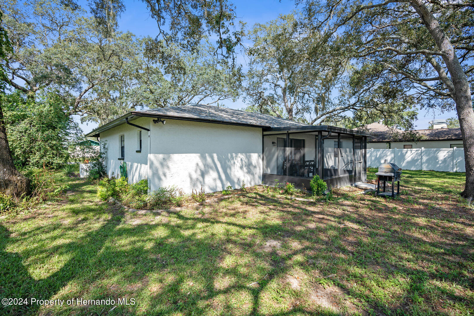 2004 Nobleton Avenue Spring Hill, FL 34608 - Photo 30 of 38 a backyard of a house with table and chairs