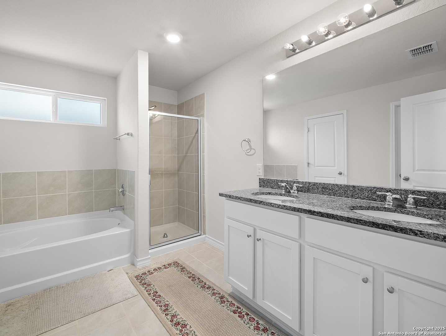 5022 Dancing Gopher San Antonio, TX 78261 - Photo 7 of 36 a bathroom with a granite countertop sink a mirror a bathtub and shower