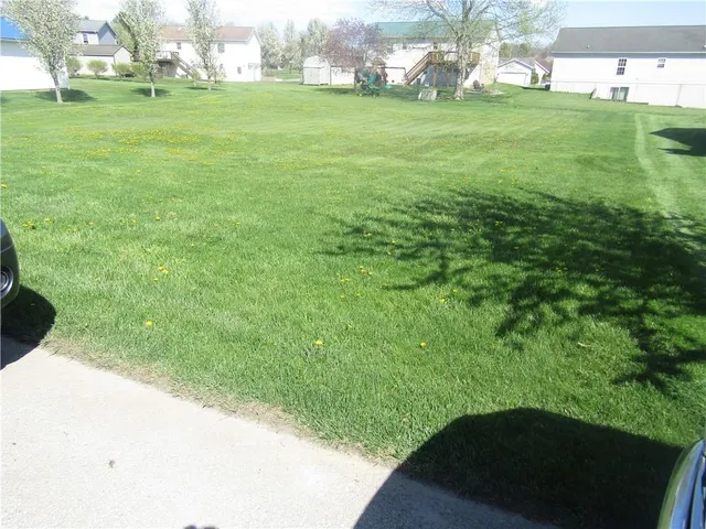 a view of a white house with a yard and garage