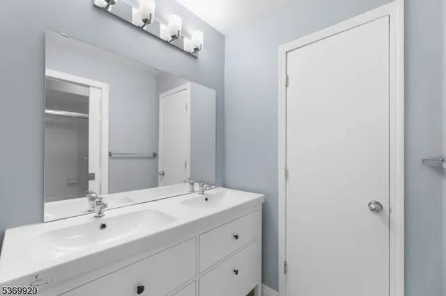 a bathroom with a sink vanity and mirror