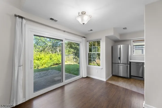 a view of a kitchen with a stove fridge and wooden floor