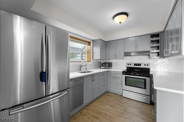 a kitchen with stainless steel appliances granite countertop a refrigerator and a stove top oven