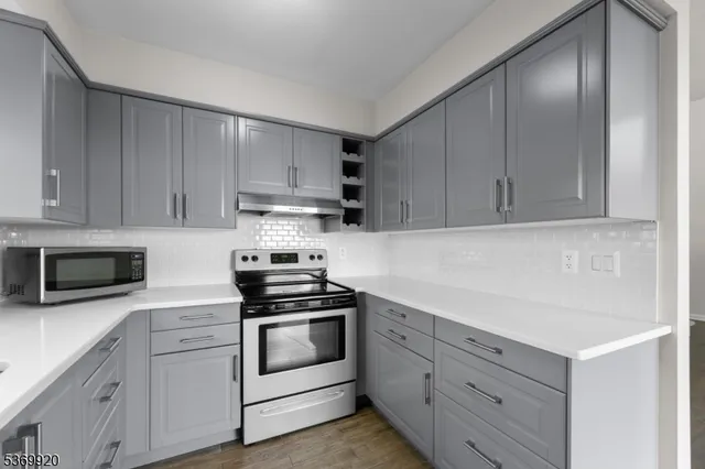 a kitchen with granite countertop white cabinets and white appliances