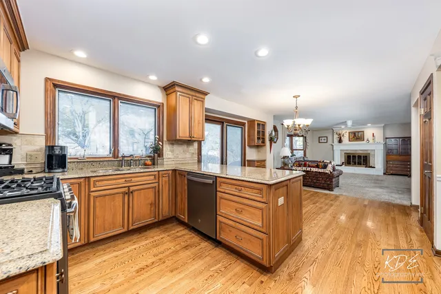 a large kitchen with stainless steel appliances granite countertop a stove and cabinets