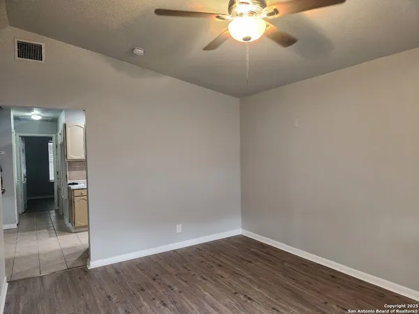 a view of an empty room with wooden floor