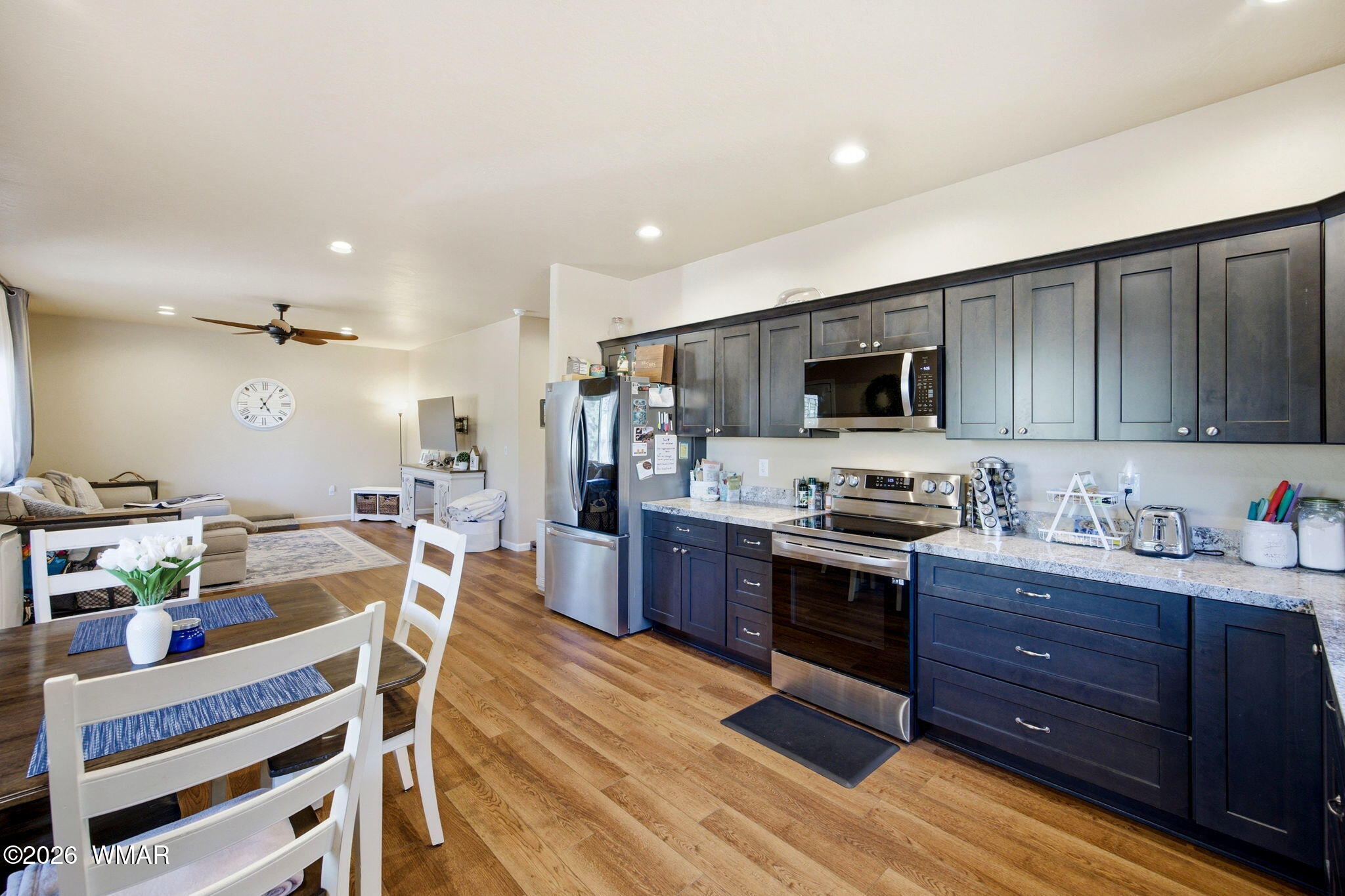 588 Rim Road Pinedale, AZ 85934 - Photo 11 of 30 a open kitchen with stainless steel appliances granite countertop a stove top oven a sink dishwasher a dining table and chairs with wooden floor