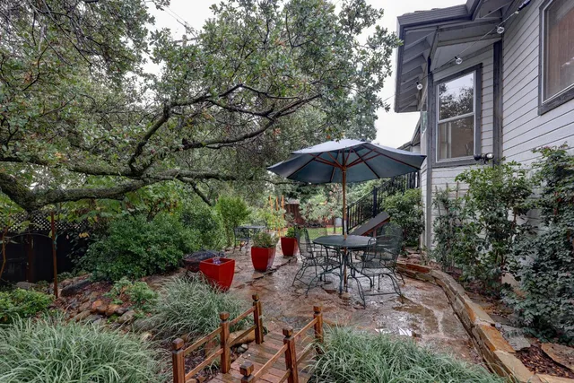 a view of a patio with table and chairs under an umbrella