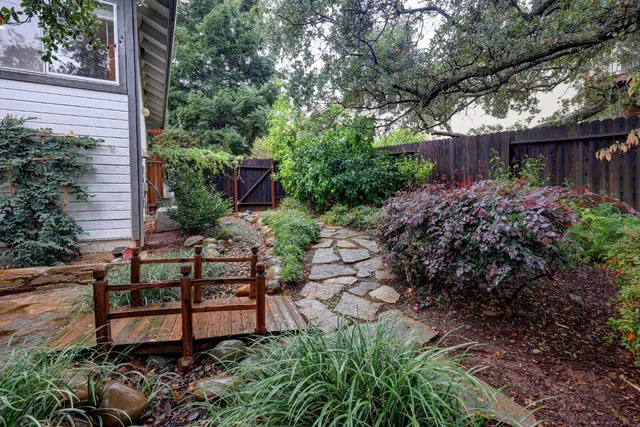 a view of a chair and tables in the back yard of the house