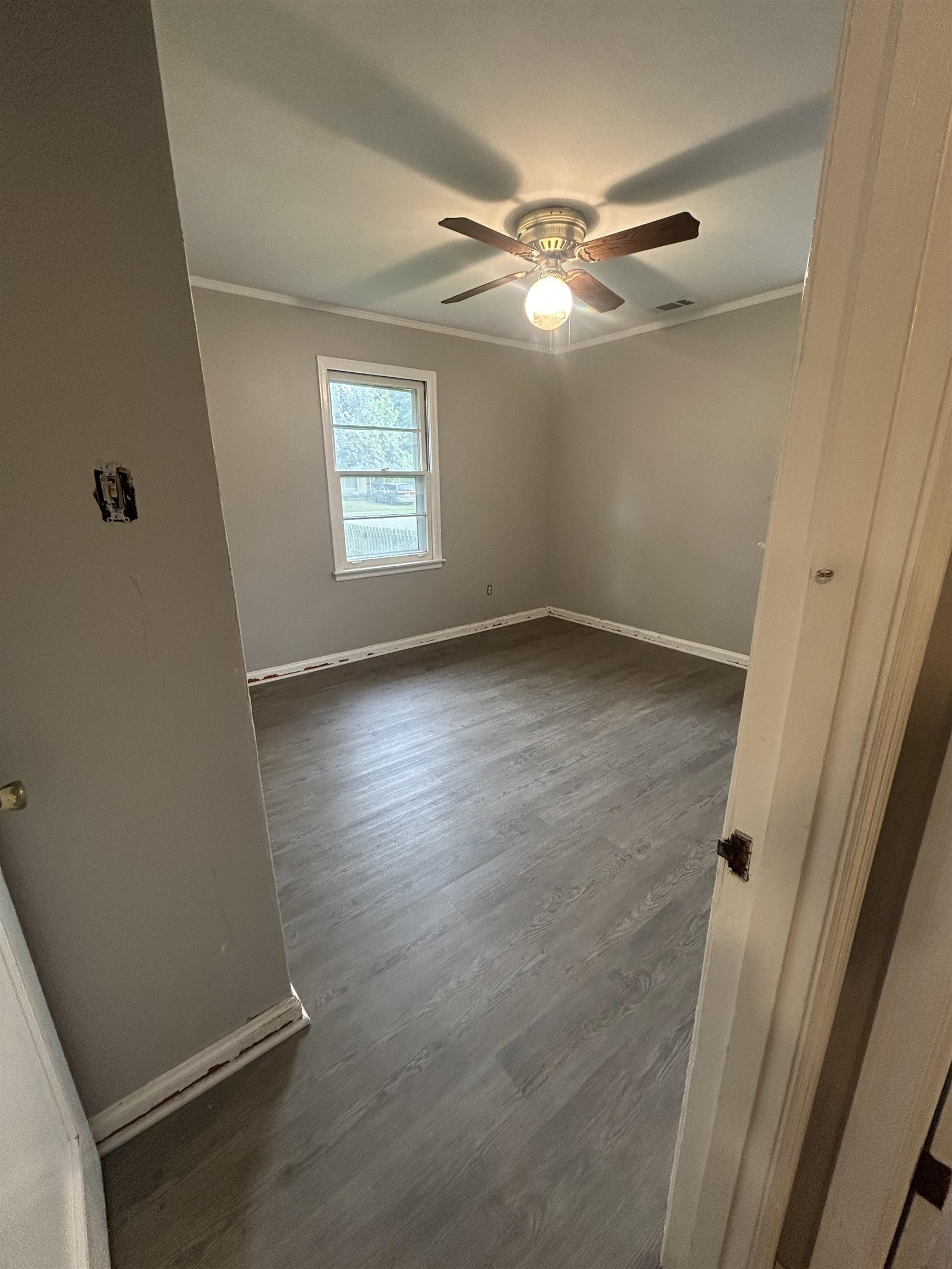 4631 Sea Isle Road Memphis, TN 38117 - Photo 17 of 28 Empty room with crown molding, a ceiling fan, baseboards, and dark wood finished floors