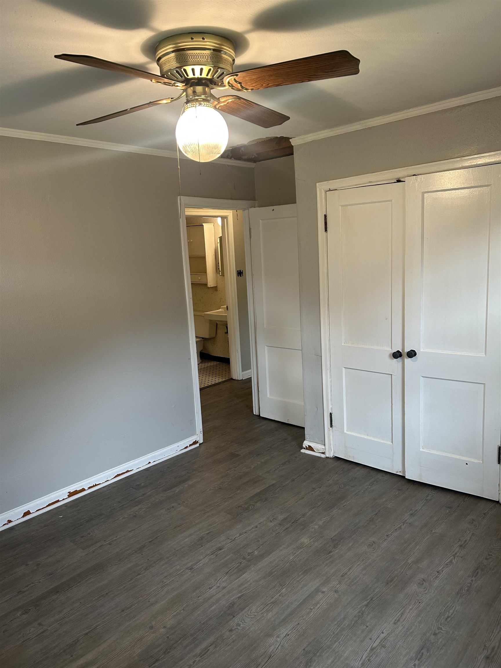 4631 Sea Isle Road Memphis, TN 38117 - Photo 18 of 28 Unfurnished bedroom featuring dark wood-style flooring, crown molding, a closet, a ceiling fan, and baseboards